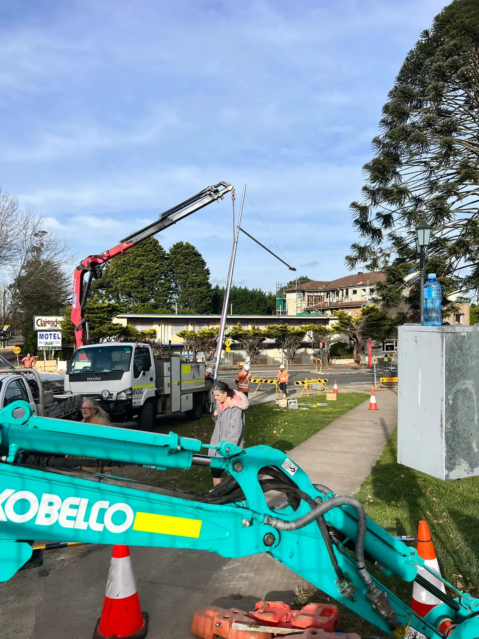 Crane lifting a new power pole into place
