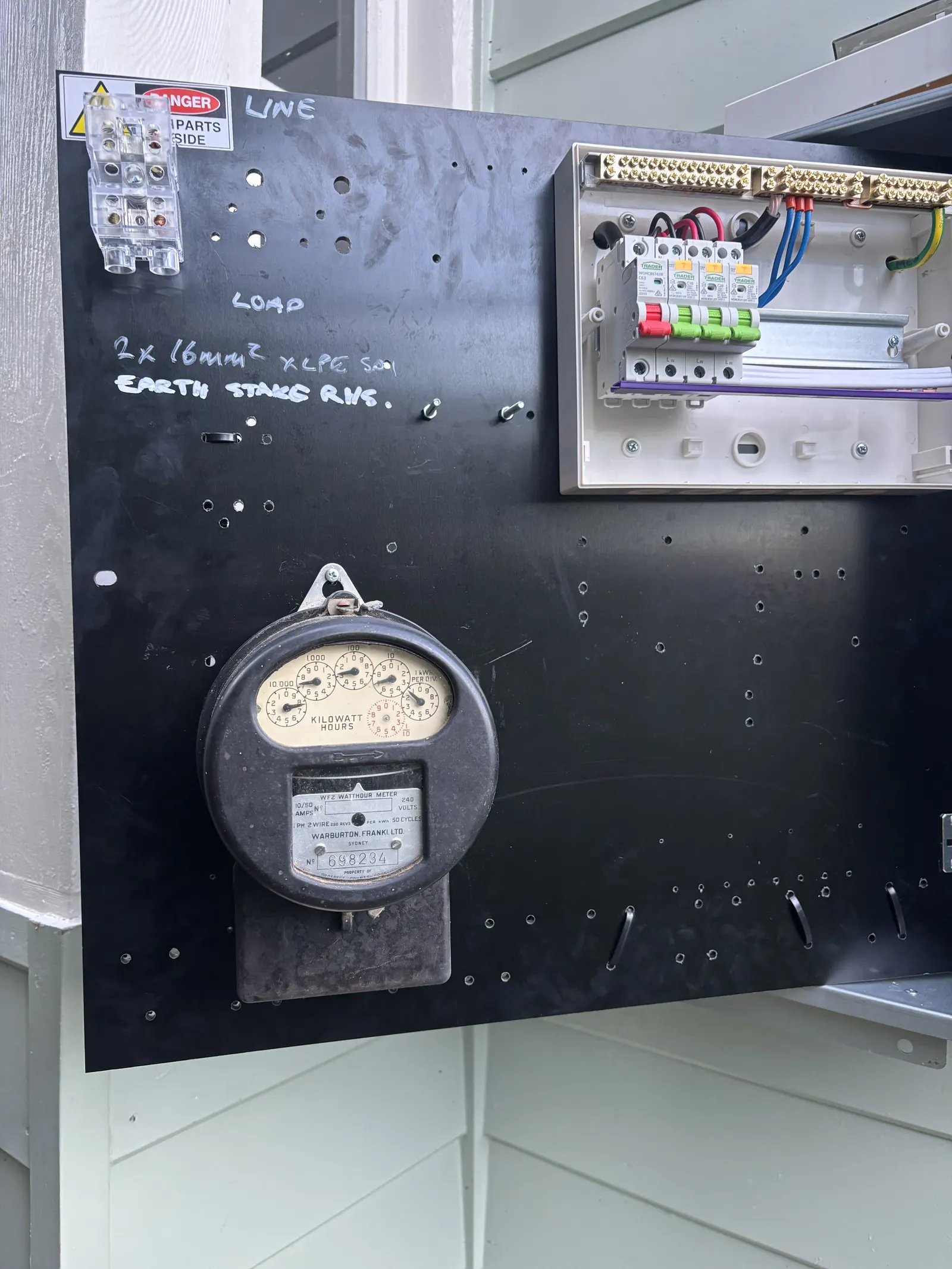 Old meter board being inspected before replacement