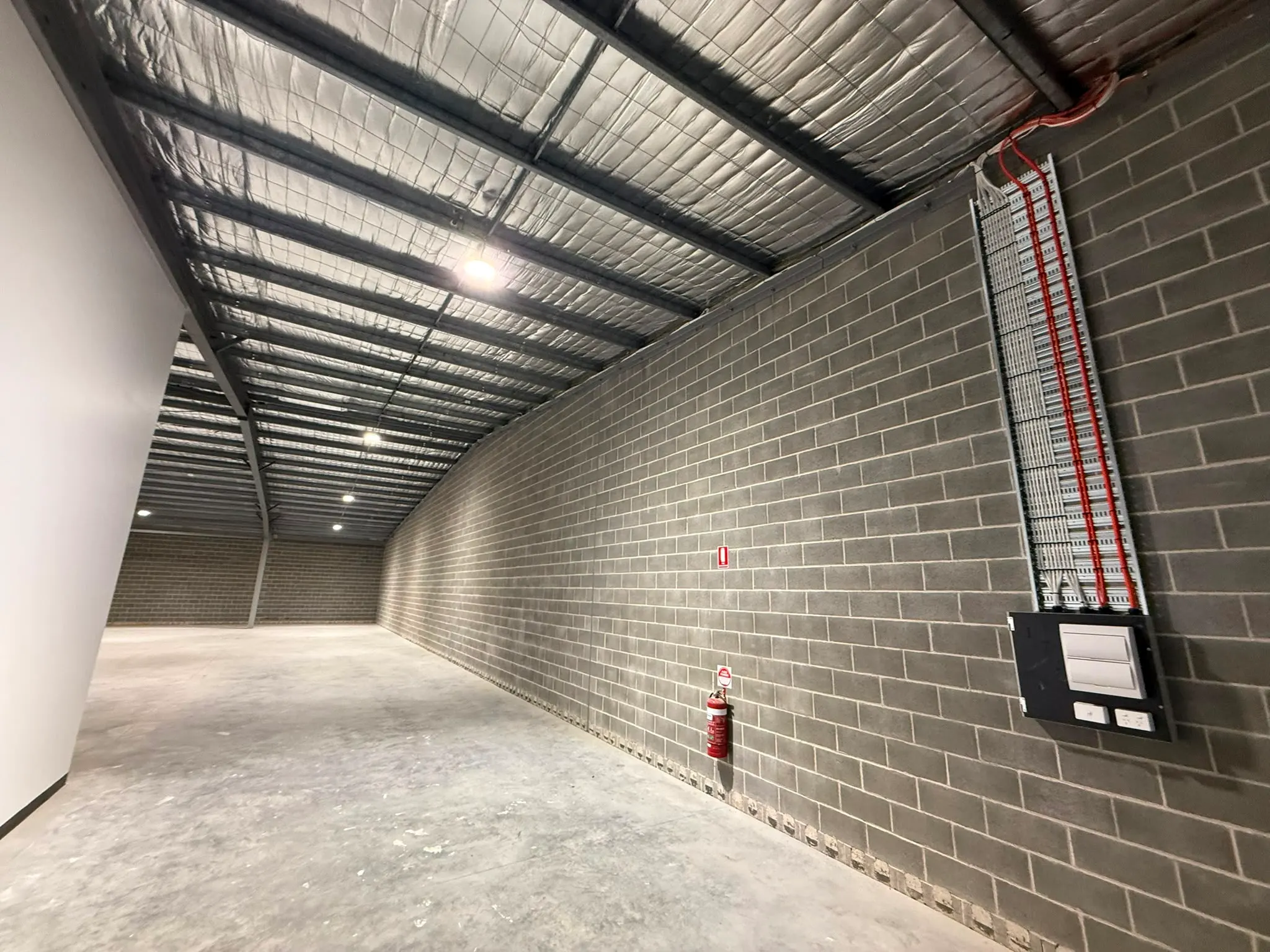 Warehouse with wall-mounted switchboard and high-bay lights